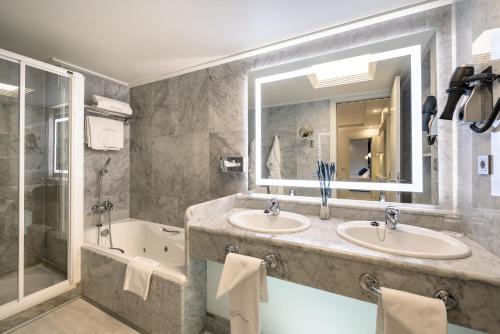 桑坦德桑特玛尔酒店的浴室配有2个盥洗盆、浴缸和淋浴。