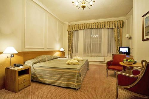 伊斯特布恩卡文迪什酒店的配有一张床和一把椅子的酒店客房