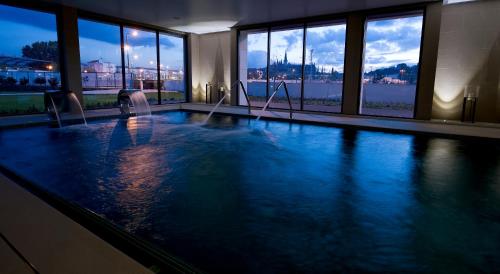 巴塔拉巴塔利亚别墅酒店的一座大型游泳池,位于一座带窗户的建筑内