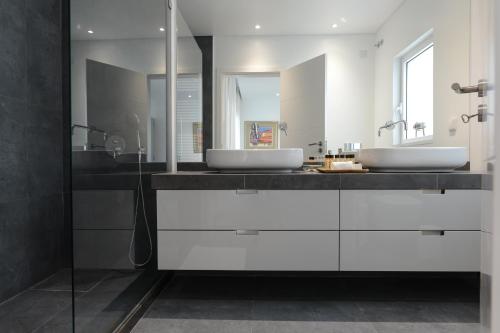 里斯本Estrela Luxury Apartment的浴室设有2个水槽和白色橱柜