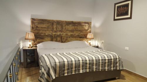 El MînaAzur Suites Hotel & Apartments的一间卧室配有一张大床和木制床头板