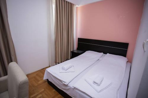 萨拉热窝Hotel Beograd - Yu的一间卧室配有一张带两条白色毛巾的床