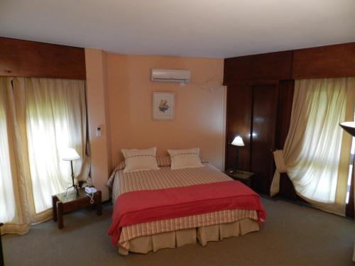 康考迪亚Hotel Ayuí Resort & spa Termal的一间卧室配有一张带红色毯子的大床