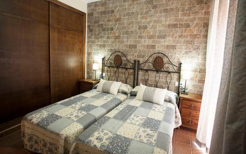阿拉色那卡萨农村辛科巴尔肯斯旅馆的一间卧室设有一张床和砖墙