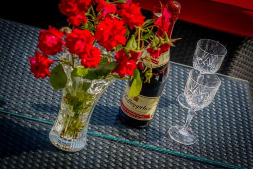 斯顿Apartments Ivanka的一瓶葡萄酒和一瓶花在桌子上