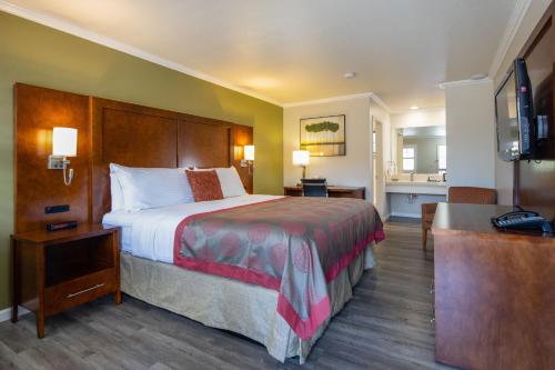 山景城华美达山景酒店的酒店客房设有一张大床和一间浴室。