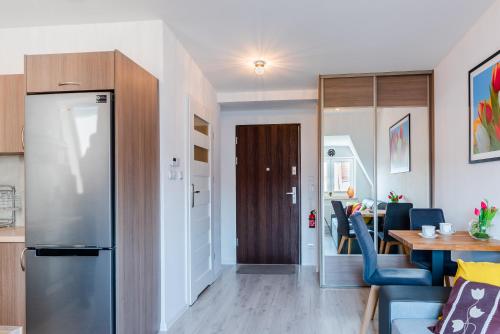 什切青Tulip-Apartments - Jagiellońska 24 poddasze bez windy的厨房以及带冰箱和桌子的用餐室。