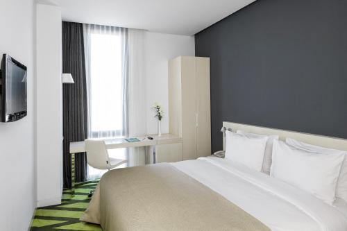 盖布泽沃克因酒店的一间卧室配有一张床、一张书桌和一个窗户。