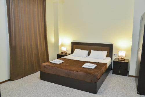第比利斯Hotel Garden的一间卧室配有一张带2个床头柜的大床