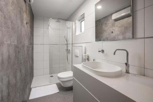 普纳特Holiday Homes Kanajt的白色的浴室设有水槽和卫生间。