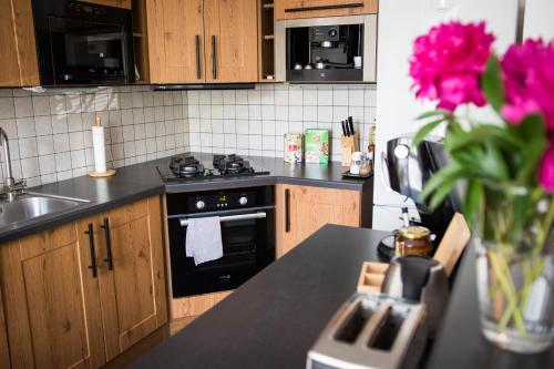 俄斯特拉发Apartment Poruba STREET VIEW的厨房配有炉灶和粉红色花卉台面。
