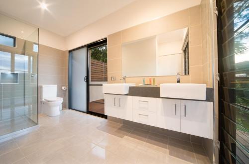 Palm Grove幽静雨林度假酒店的一间带两个盥洗盆和卫生间的浴室