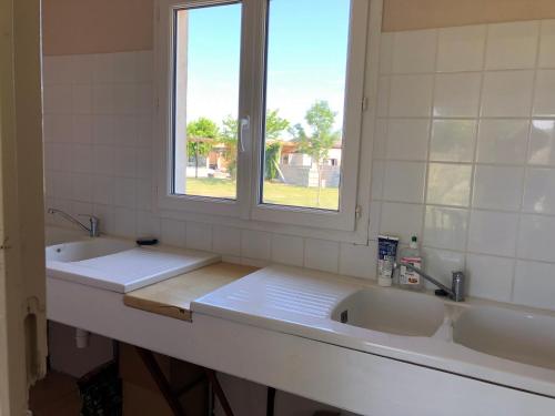 Jau-Dignac-et-LoiracLE MEDOC AUX 4 VENTS的一间带两个盥洗盆和窗户的浴室