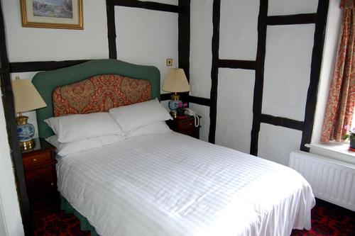 塞奇菲尔德Dun Cow Inn的卧室配有白色的床和2扇窗户。