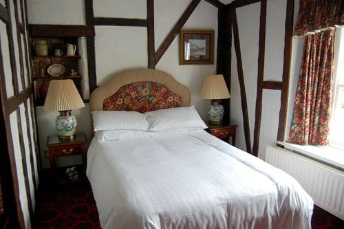 塞奇菲尔德Dun Cow Inn的一间卧室配有一张白色的床,桌子上配有两盏灯
