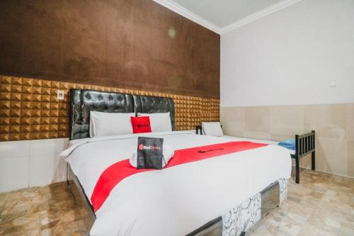 棉兰RedDoorz near Millennium ICT Center Medan的卧室配有一张大白色床和红色毯子
