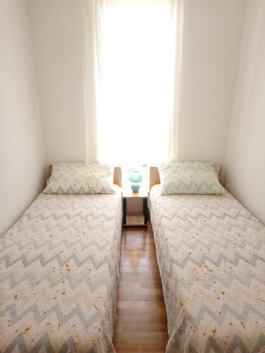 奥帕提亚Charming Hill Apartment的带窗户的客房内设有两张单人床。
