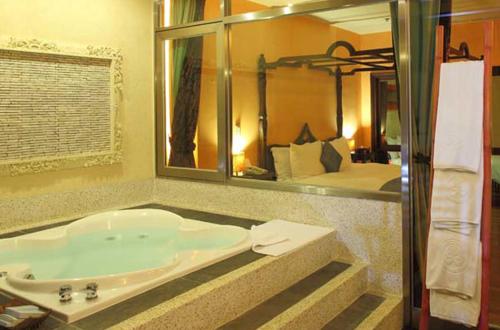 垦丁大街垦丁福华Villa的一间带大镜子和浴缸的浴室