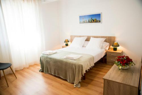 格罗韦Casa Mamalola的卧室配有白色大床和白色枕头