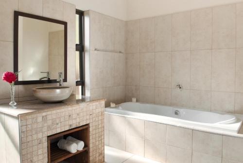 香槟谷Ama Casa Cottages的带浴缸、水槽和镜子的浴室