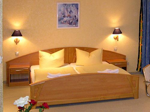 SeelowWaldhotel Seelow的一间卧室配有一张带枕头的大型木制床。