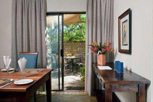 香槟谷Ama Casa Cottages的一间带桌子的用餐室,享有庭院的景致。