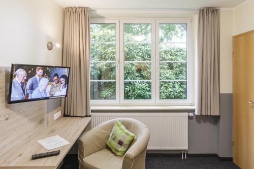 库克斯港Gästehaus Alexandra的客厅配有电视、椅子和窗户