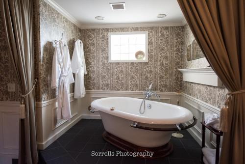 罗切斯特百老汇旅馆的带浴缸的浴室和窗户。