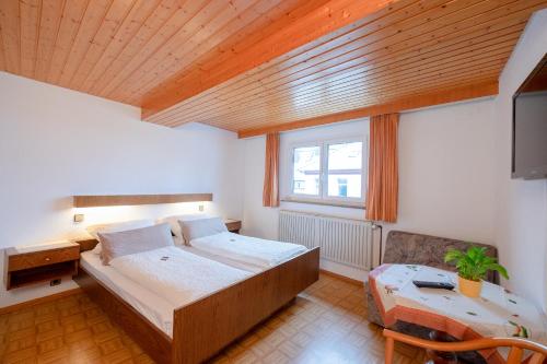 Vöhrenbach盖斯豪弗兹姆奥斯恩酒店的一间卧室配有一张床、一张书桌和一个窗户。