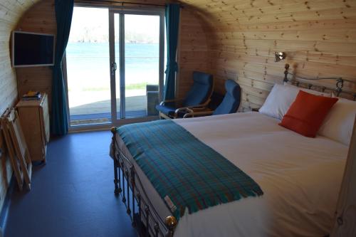 ValtosThe Beach Bothies的一间卧室设有一张床和一个大窗户