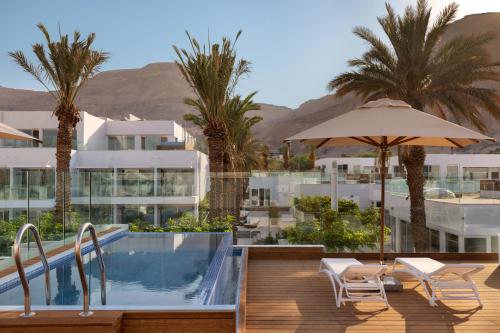 恩波其克Herbert Samuel Milos Dead Sea的一个带游泳池和棕榈树的度假村