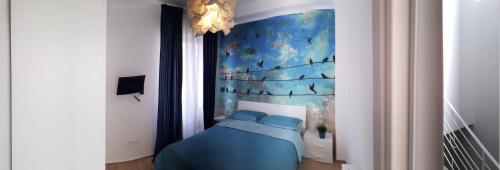 圣贝内代托-德尔特龙托Reggia del sole的卧室配有一张蓝色的床,墙上挂着一幅画