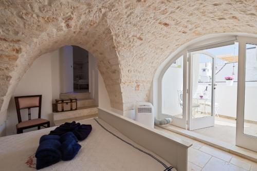 奥斯图尼安蒂卡彼得拉比安卡度假屋的一间卧室设有一张大床和拱门