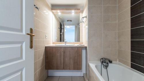 滨海卡涅Vacancéole - Résidence Le Crystal的浴室配有盥洗盆和浴缸。