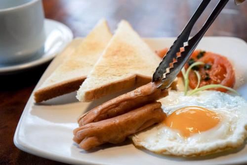 日惹The Capsule Malioboro的包括鸡蛋香肠和烤面包的早餐食品