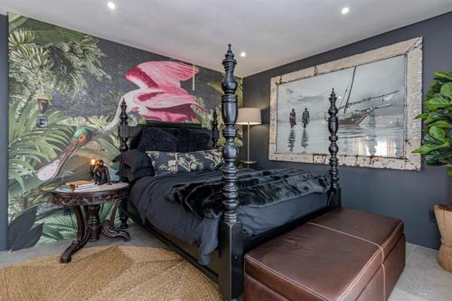 伯诺尼The Hideaway的一间卧室配有一张床和壁画墙