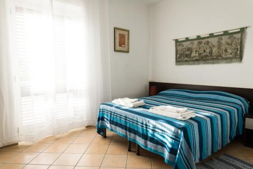 索威拉托玛里纳托雷昂契纳勒酒店的一间卧室配有一张带蓝白色毯子的床