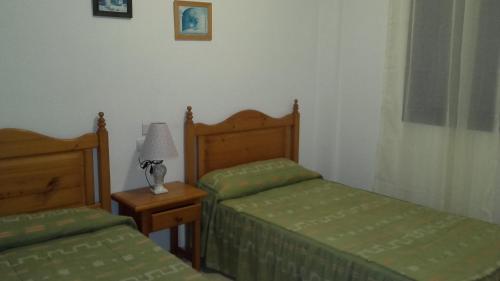 阿瓜杜尔塞Apartamento 3 Hab. en el Parador的一间卧室配有两张床和一张带台灯的桌子