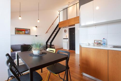 斯科普里城市服务公寓的厨房以及带桌椅的起居室。