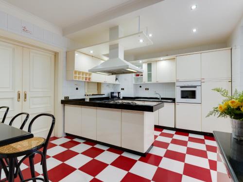 安齐奥Il canto delle Sirene的厨房配有白色橱柜和红色及白色的格子地板。