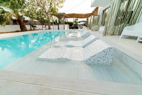 Sant Francesc de s'EstanyPAIISE Hotels的游泳池旁设有桌椅