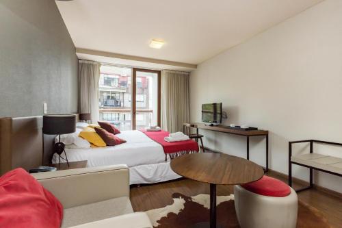 布宜诺斯艾利斯PALERMO EVOQUE Thames的酒店客房配有一张床铺和一张桌子。