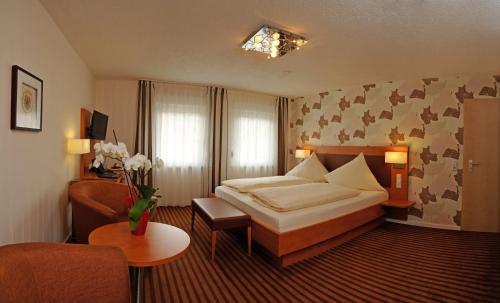 Sindringen奴斯旺酒店的配有一张床和一把椅子的酒店客房