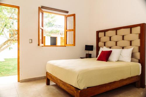 科苏梅尔Kinta Kan Hotel Boutique Cozumel的一间卧室设有一张大床和一个窗户。