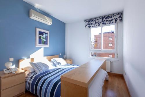 马德里RASTRO的蓝色的卧室设有床和窗户
