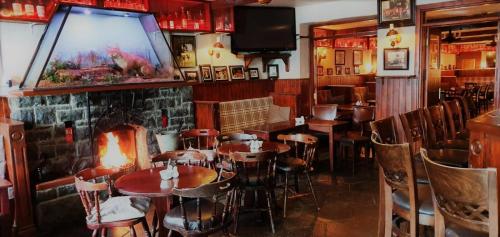 康镇Danagher’s Hotel Cong的一间带桌椅和大屏幕的餐厅