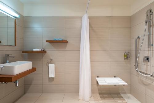 泰帕Taipa Beach Resort的带淋浴、盥洗盆和卫生间的浴室