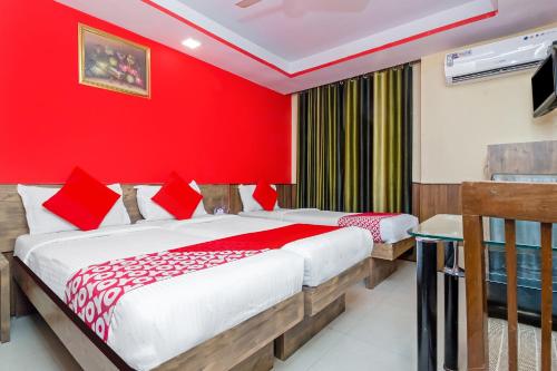 孟买Hotel Arma Residency的红色墙壁客房的两张床
