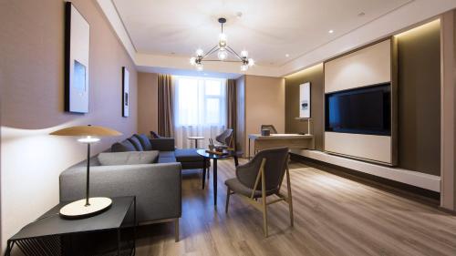 侯马侯马新田广场亚朵酒店的带沙发、桌子和电视的客厅