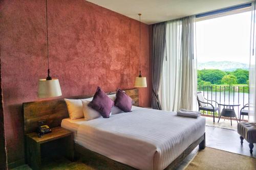 北碧荣耀桂河酒店 的一间带大床的卧室和一个阳台